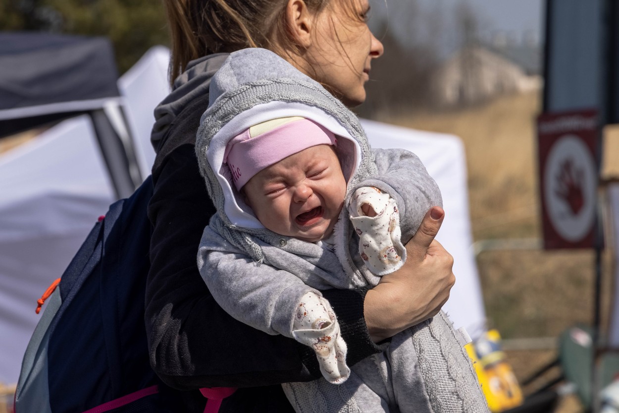 Un an de război. Momentele emoționante cu refugiații ucraineni la granițe, care fugeau de invazia Rusiei | GALERIE FOTO - Imaginea 16