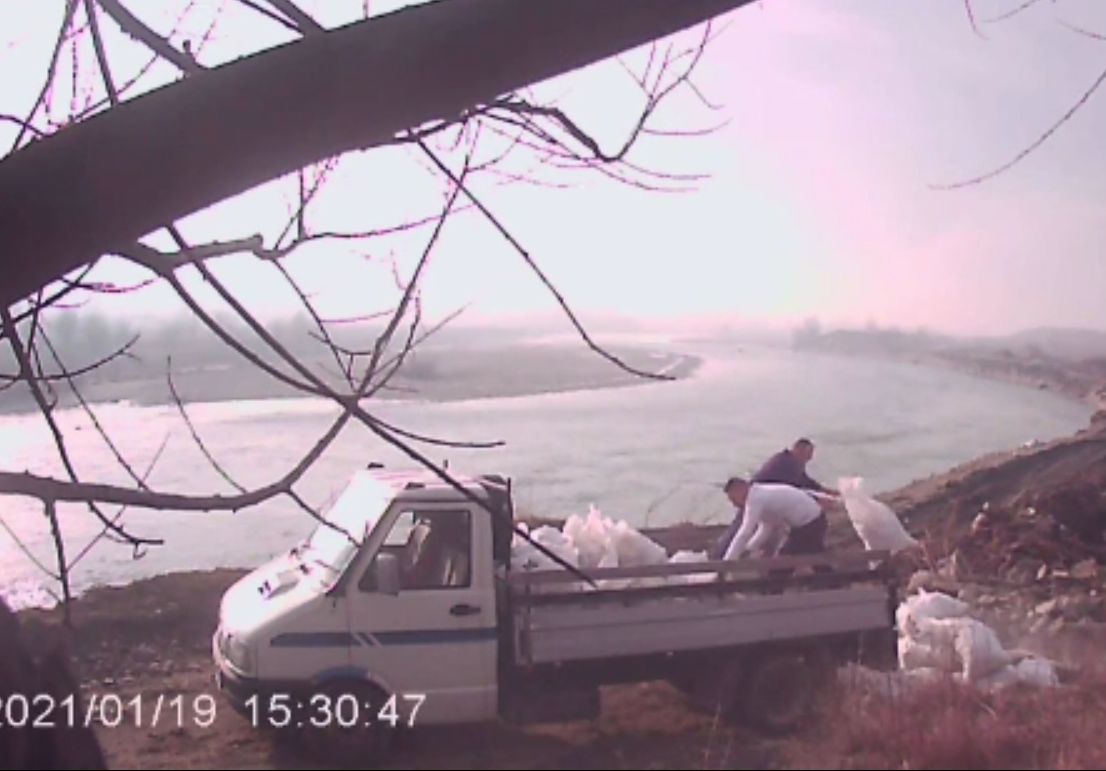 Doi bărbați, filmați în timp ce aruncă zeci de saci cu moloz pe malul Jiului. Polițiștii îi caută
